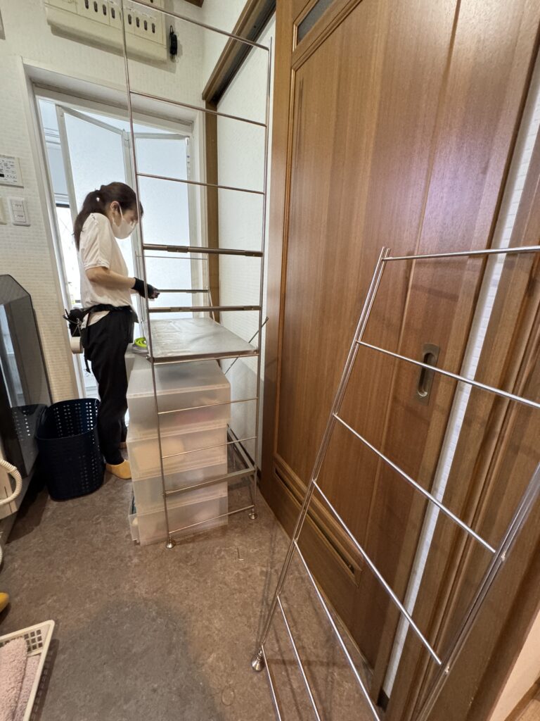 大阪の整理収納アドバイザーが洗面所のシェルフを整えている作業風景